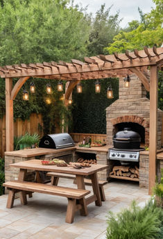 an outdoor bbq and picnic table with lights hanging from the pergolated roof