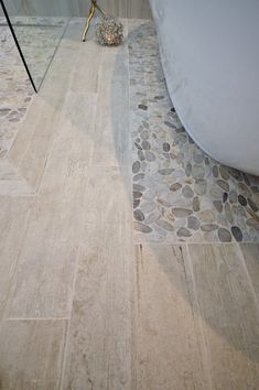 a bathroom with stone flooring and a bathtub