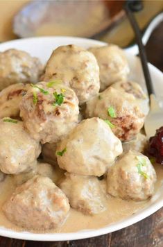 a white plate topped with meatballs covered in gravy