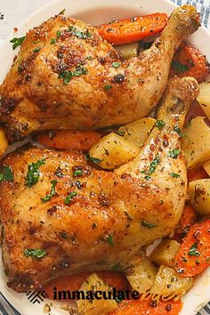 two chicken legs with potatoes and carrots on a plate