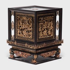 an intricately decorated wooden box with carvings on the front and sides, sitting on a black surface