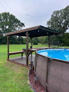 an above ground pool with a deck and gazebo next to it in the grass