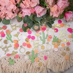 pink flowers and gold confetti on a white table cloth with tassels