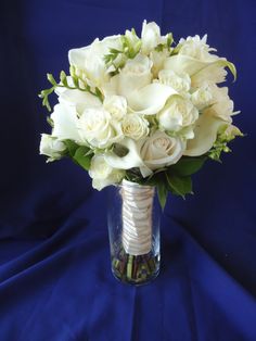 a vase filled with white flowers on top of a blue cloth