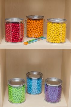 the shelves are filled with different types of candies and crayons in tins