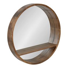 a round mirror sitting on top of a wooden shelf