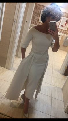 a woman is taking a selfie in the mirror wearing a white dress and heels