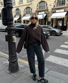 Embrace the fall season with a chic and cozy Parisian look! This outfit features a chocolate brown cable-knit turtleneck, perfectly paired with relaxed black jeans and classic Adidas sneakers. The black crossbody bag and oversized sunglasses complete this effortlessly cool, casual city vibe. Ideal for a stroll through Paris or any stylish city outing. #ParisianStyle #FallOutfit #StreetStyle #CozyFashion #CityChic #EffortlessLook #AutumnWardrobe #ParisVibes #FallFashion Aesthetic Overalls Outfit, Adidas Samba Outfit, Samba Outfit, Overalls Outfit, Skandinavian Fashion, Outfit Chic, Corporate Outfits, Outfit Jeans, Cozy Pullover