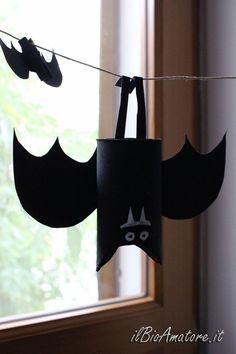 paper bats hanging from a clothes line in front of a window