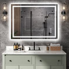 a bathroom vanity with a large mirror above it and lights on the wall behind it