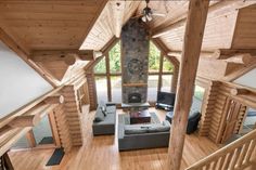 a living room filled with furniture and a fire place in the middle of a wooden floor