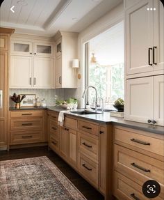 a kitchen filled with lots of wooden cabinets and counter top space next to a window