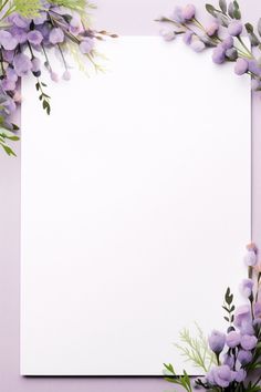 an empty paper surrounded by purple flowers and greenery on a pastel pink background