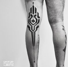 a man's leg with tattoos on it and an arrow tattooed on the side