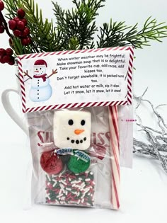 a christmas treat bag with marshmallows, candy cane and a snowman ornament