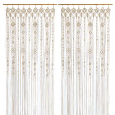 two white curtains with fringes hanging from them