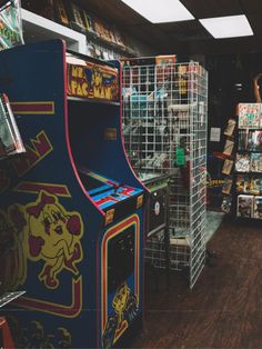 an arcade machine in the middle of a room filled with other games and merchandise items