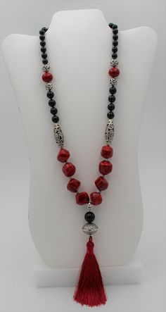 Gorgeous red coral necklace, accented with silver- plated filigree beads and glossy black onyx. Necklace is finished with a matching red tassel. Necklace is 24 inches long plus a 4 1/2 inch tassel.  Pictured with matching pierced earrings, which are available elsewhere in this shop site. This is an impressive statement necklace. Elegant Red Beaded Necklace With Black Beads, Traditional Red Necklaces With Black Beads, Elegant Red And Black Beaded Necklaces, Traditional Red Necklace With Black Beads, Elegant Red And Black Beaded Necklace, Red Spiritual Jewelry With Black Beads, Spiritual Red Jewelry With Black Beads, Elegant Handmade Red Long Necklace, Red Onyx Jewelry For Gift