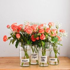 three mason jars with flowers in them sitting on a table