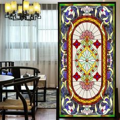 a large stained glass window in the middle of a dining room with chairs and table