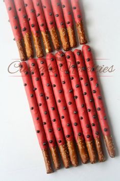 several sticks with holes are lined up on a white surface and have chocolate chips in them