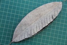 a piece of silver colored material sitting on top of a green table next to scissors