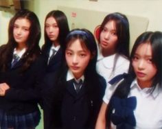 several girls in school uniforms posing for the camera