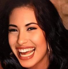 a close up of a smiling woman with dark hair