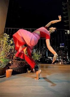 two people are dancing on the floor in front of some plants and potted plants