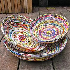 three bowls made out of magazines sitting on top of a wooden table next to each other