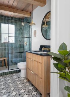 a bathroom with green tile and wood accents