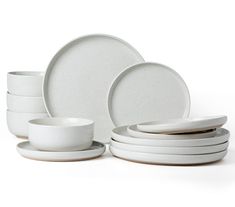 a stack of white plates and cups on a white background