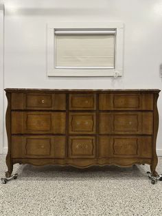 a large wooden dresser sitting next to a window