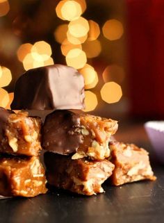 several pieces of chocolate covered candy sitting on top of a table next to a christmas tree