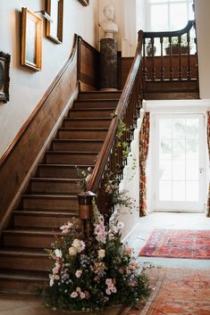 a staircase with flowers and pictures on the wall