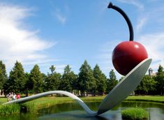 an apple sculpture sitting on top of a pond