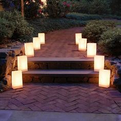 some lights are lit up in the shape of squares and rectangles on a brick path