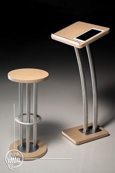 a small table with a tablet on it next to a stool that also has a cell phone