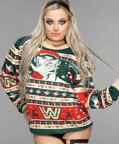 a woman with long hair wearing a green and red ugly ugly christmas sweater that has an image of a wrestling wrestler on it