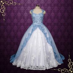 a blue and white wedding dress on display in front of a purple wall with an ornate frame