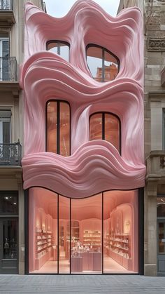 an unusual pink building with lots of windows