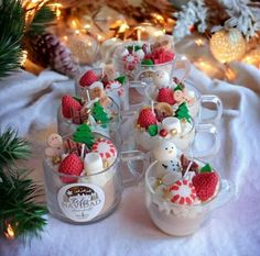 several small cups filled with desserts on top of a table next to christmas decorations