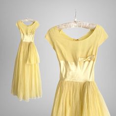 Fabulous vintage 1950s baby chick yellow mesh gown with satin details. This vintage gown has a fitted bodice with a wide satin waist design finished with a charming off center bow. It has a super full skirt designed beautifully with two layers of fine yellow mesh and a giant looped mesh sash on the hip. Center back metal zipper for closure and it is fully lined. SIZE: Small Bust: 32" Waist: 24" Hips: Full Length: 57" CONDITION: Excellent vintage condition. The hem of the dress is raw and has a f Yellow Retro Evening Dress, Retro Yellow Wedding Dress, 50s Yellow Dress, 1950s Style Yellow Party Dress, 1950s Yellow Dress, Yellow 80s Dress, Yellow 50’s Dress, Mesh Gown, Vintage Gowns