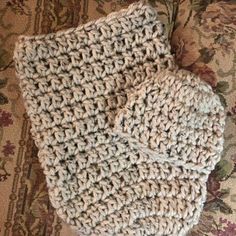 a pair of crocheted mitts sitting on top of a couch