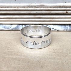 Two part interlocking hallmarked silver ring with matt and polished finishes based on your chosen city skyline. Makes a wonderful and unique keepsake of your honeymoon, special holiday or country of birth. Please specify a place name, and Hannah will work with you to create a silhouette before she starts making the ring. She can work from your own photograph if you have one of the panorama you would like or can source a suitable image with you. This ring is 8mm wide. Please ensure when selecting Cityscape Rings, Unique Silver Rings, Map Jewelry, Silver City, Place Names, City Skyline, Holiday Specials, Band Ring, Gift For Lover