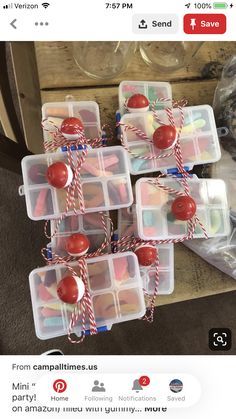 plastic containers filled with candy and candies on top of a wooden table next to wine glasses