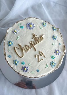 a white cake with blue and yellow flowers on it that says diaper 2a in gold lettering