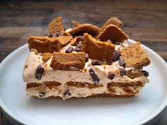 a piece of cake on a white plate with chocolate chips and marshmallows