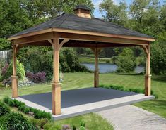 a wooden gazebo sitting on top of a lush green field