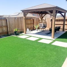 a backyard with grass and a wooden gazebo